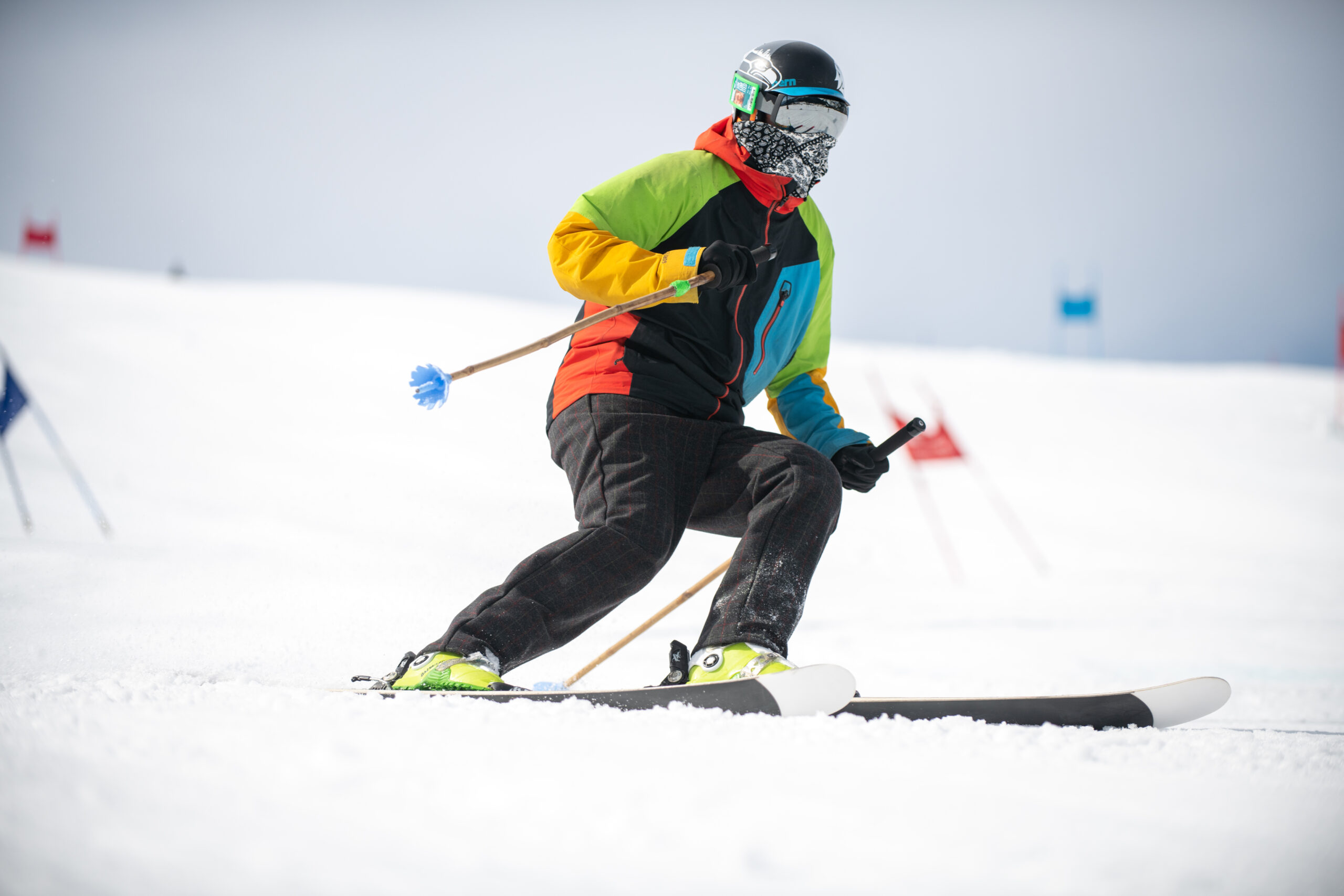 A Man in Ski Gear Skiing on Snow