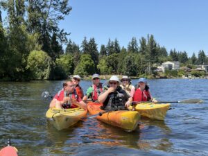 PTPs Sam, Sarina, and Faith kayaking with staff Caroline, Henry, and volunteer Monica